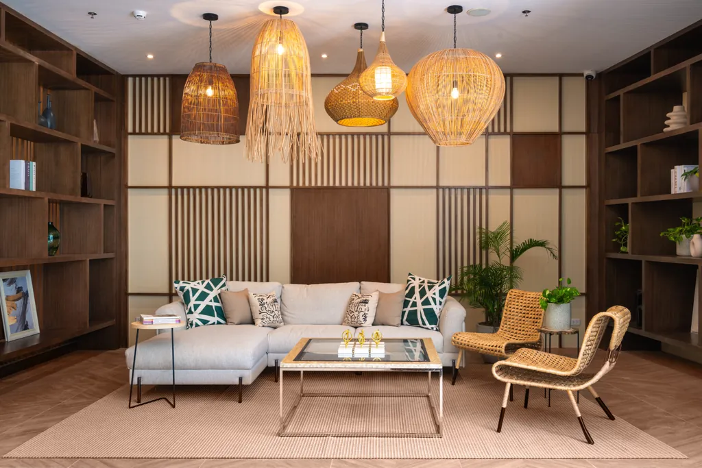 The lobby lounge of BE Residences, with woven pendant lights and warm wood panelling