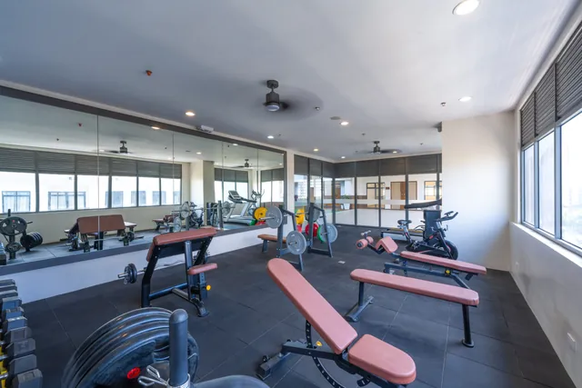 The building gym, with benches, weights and mirrors