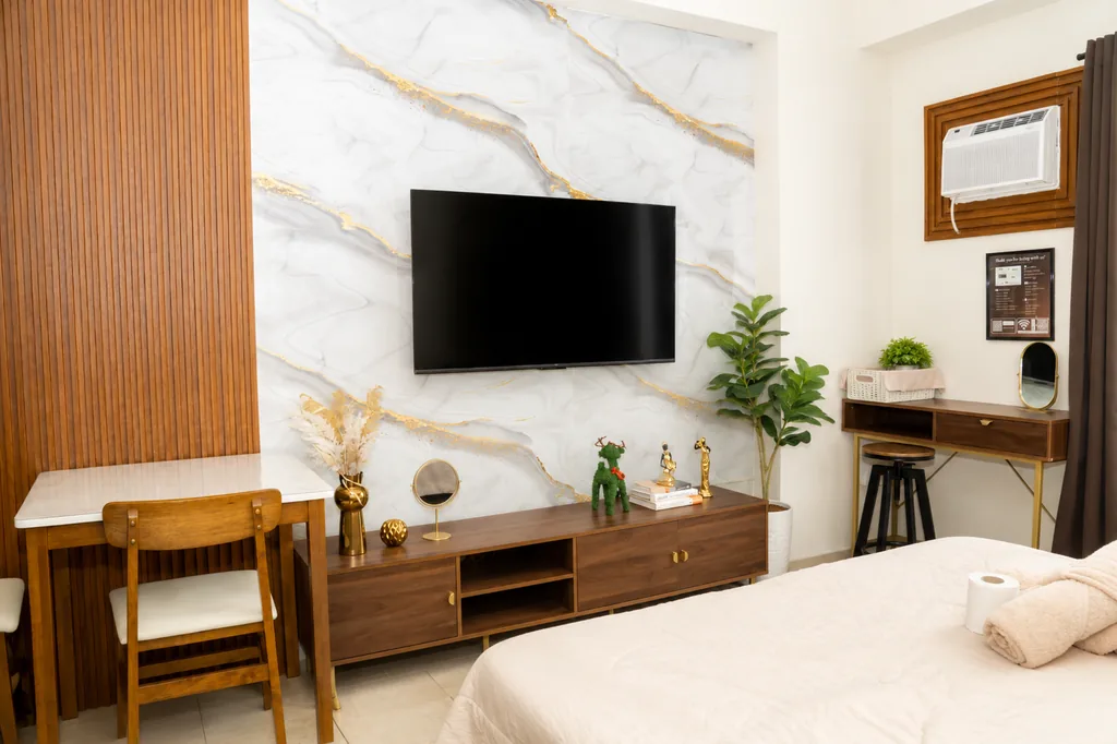 Smart TV on the marble feature wall, with the dining table and desk