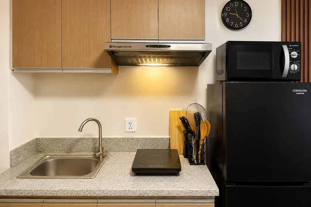 Kitchenette with induction hob, sink, fridge, microwave and utensils